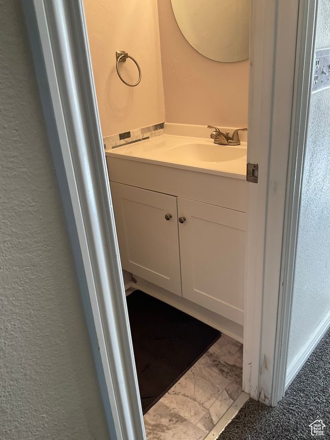 Bathroom featuring a textured wall, vanity, and marble finish floor | Image 10