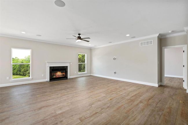 Unfurnished living room featuring light hardwood / wood-style floors, ceiling fan, and crown molding | Image 20