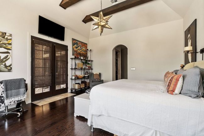 Bedroom featuring wood finished floors, lofted ceiling with beams, arched walkways, and French doors | Image 15