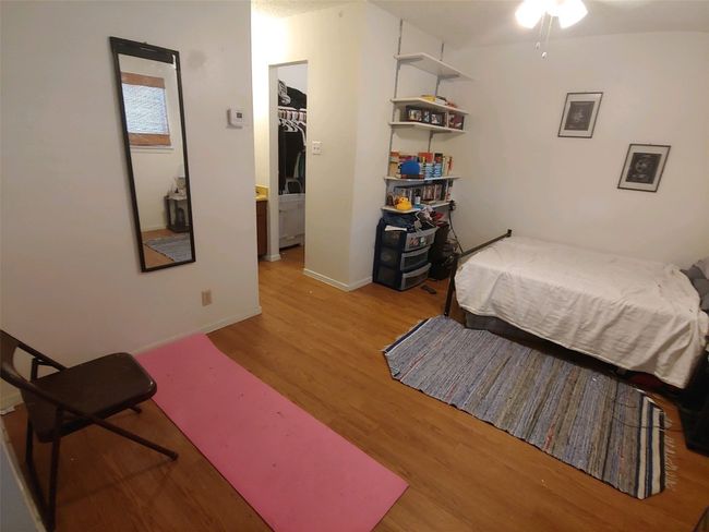 Bedroom with a walk in closet, baseboards, and wood finished floors | Image 9