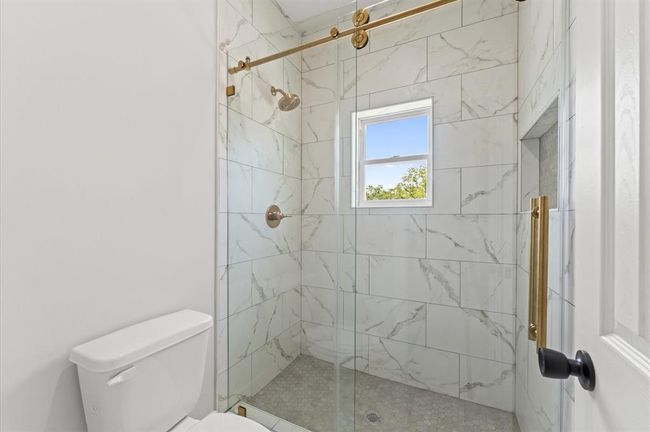 Full bathroom with modern fixtures and tile in shower. | Image 25