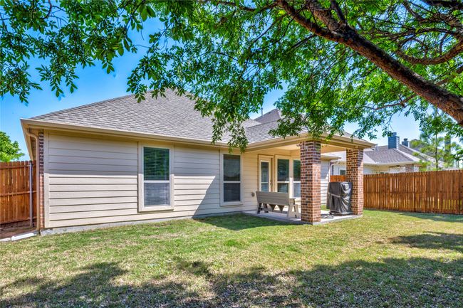 Back of property featuring a patio, a yard, a fenced backyard, and a shingled roof | Image 38
