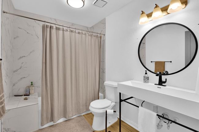 Bathroom featuring shower / bath combination with curtain, wood finished floors, and vanity | Image 28