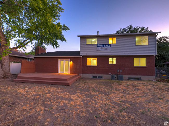 Back of house at dusk featuring a deck and brick siding | Image 8