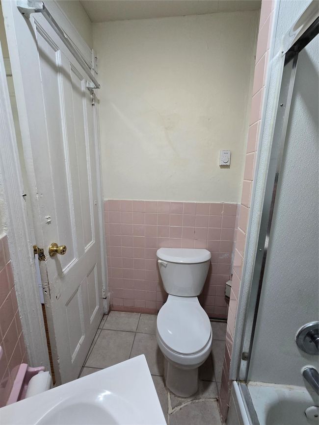 Bathroom featuring toilet, tile walls, a wainscoted wall, and tile patterned floors | Image 14