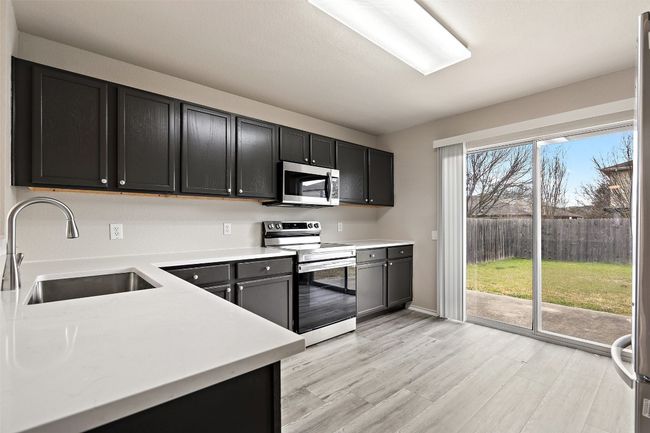 Kitchen featuring appliances with stainless steel finishes, light countertops, and light wood finished floors | Image 9
