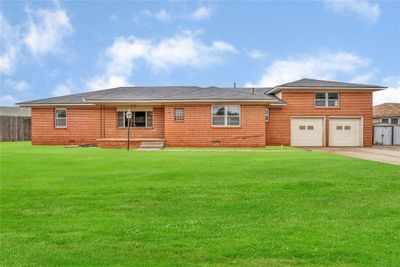 Back of house with a lawn and a garage | Image 1