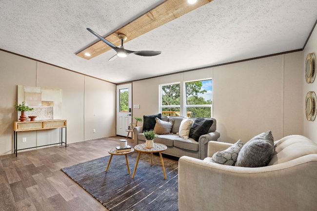 Living room with a ceiling fan, wood finished floors, a textured ceiling, and ornamental molding | Image 13