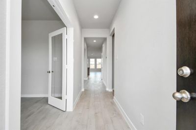 The grand entrance beckons with its soaring ceilings, adorned with elegant wood-look tile flooring featuring sleek oversized baseboards. Photo shown is example of completed home with similar plan. | Image 3