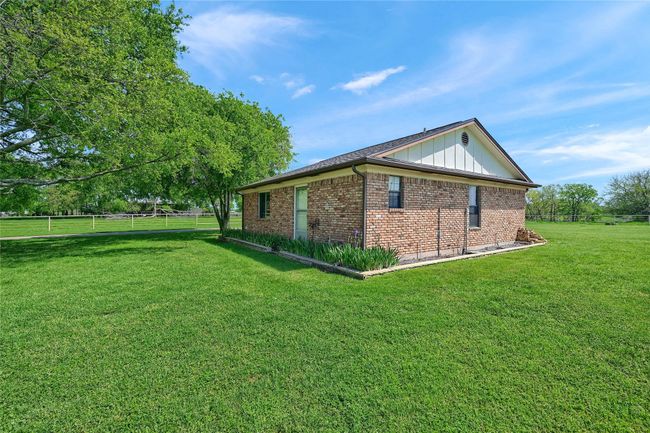 View of side of home with a yard, brick siding, and fence | Image 34