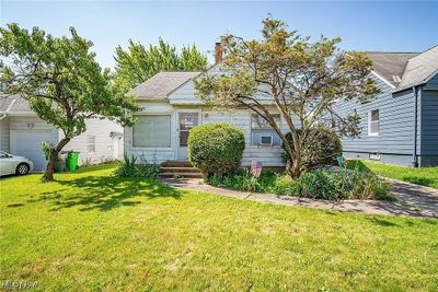 View of front of home featuring a front yard and a garage | Image 1