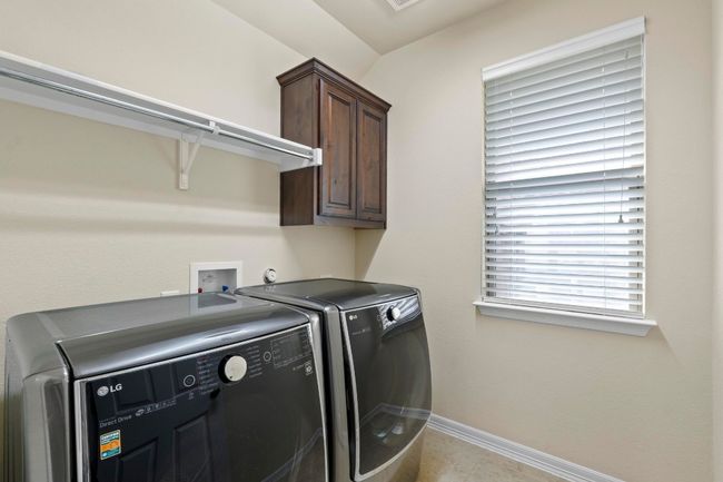 Washroom with cabinet space and washing machine and clothes dryer | Image 35
