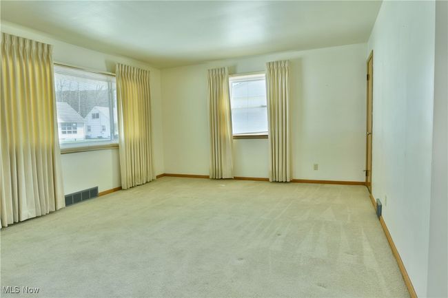 Spare room featuring plenty of natural light, visible vents, and carpet | Image 10