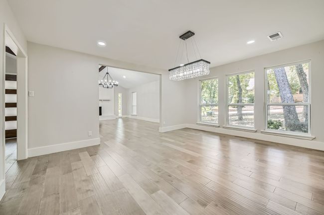 Unfurnished dining area with a chandelier, visible vents, baseboards, and plenty of natural light | Image 15