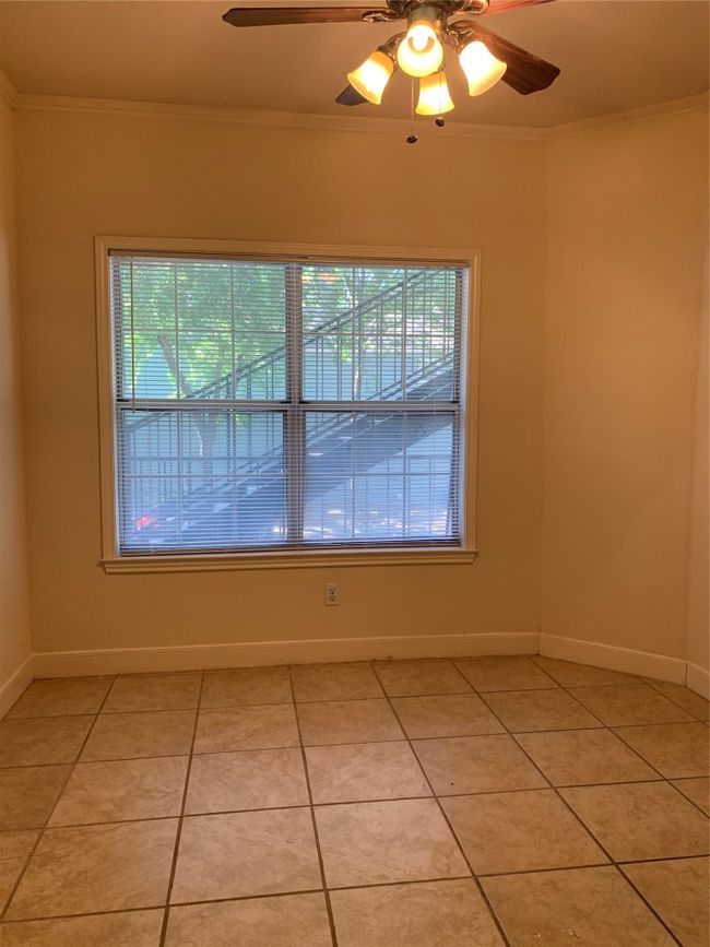 Spare room featuring light tile patterned flooring, a ceiling fan, baseboards, and ornamental molding | Image 6