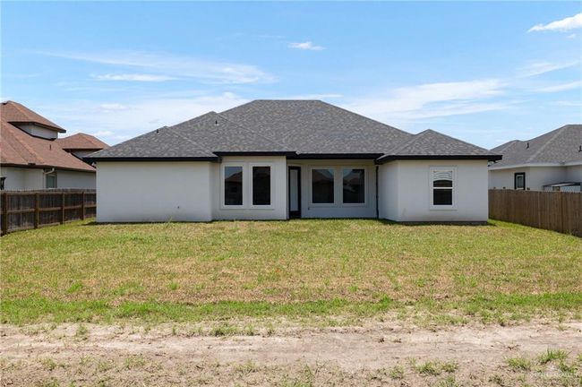 Rear view of property with roof with shingles, a fenced backyard, and stucco siding | Image 9