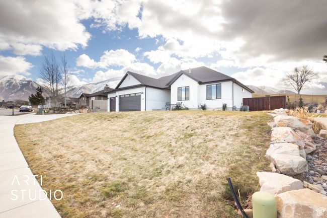 View of front of property featuring a garage, a mountain view, and a front yard | Image 4