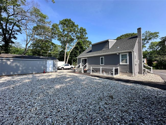 Rear view of property with a chimney, roof with shingles, and an outbuilding | Image 6