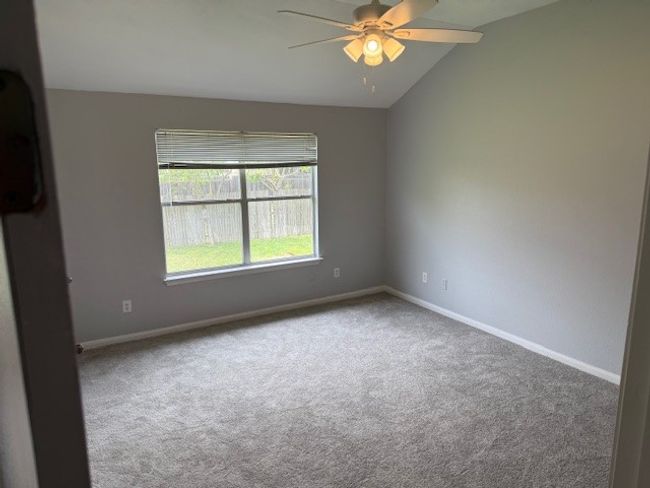 Unfurnished room featuring ceiling fan, carpet flooring, baseboards, and vaulted ceiling | Image 8