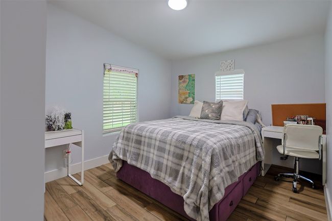 Bedroom featuring baseboards, vaulted ceiling, and wood finished floors | Image 15