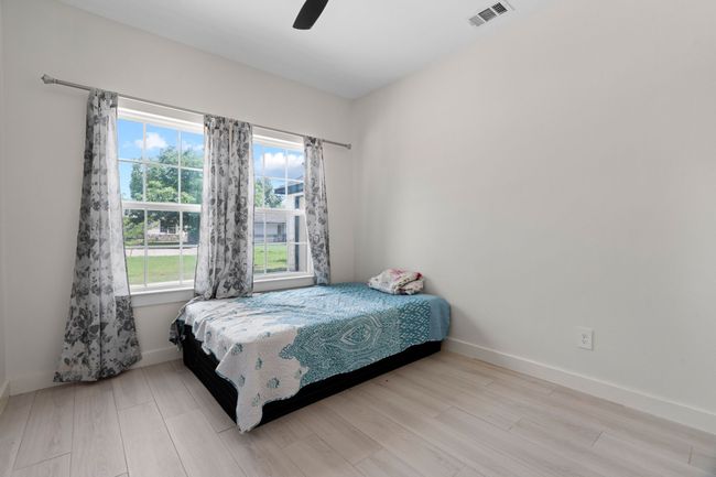 Bedroom with multiple windows, wood finished floors, and a ceiling fan | Image 30
