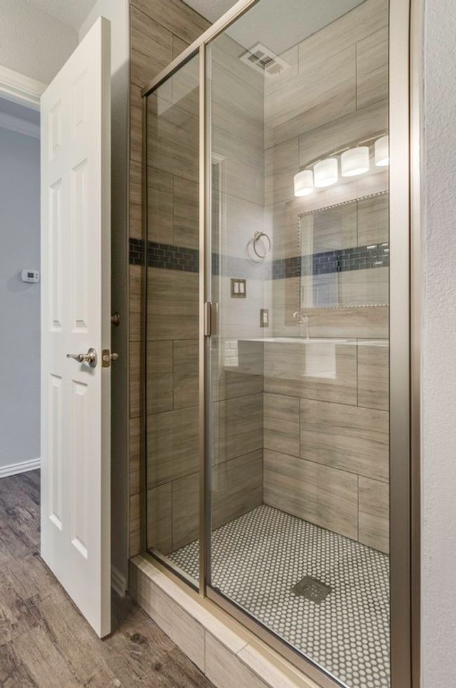 Full bath featuring a shower stall and wood finished floors | Image 32
