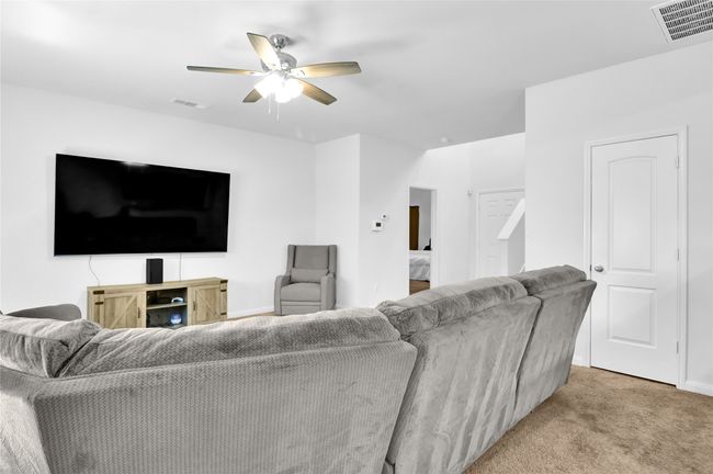 Living area featuring visible vents, a ceiling fan, and light carpet | Image 9