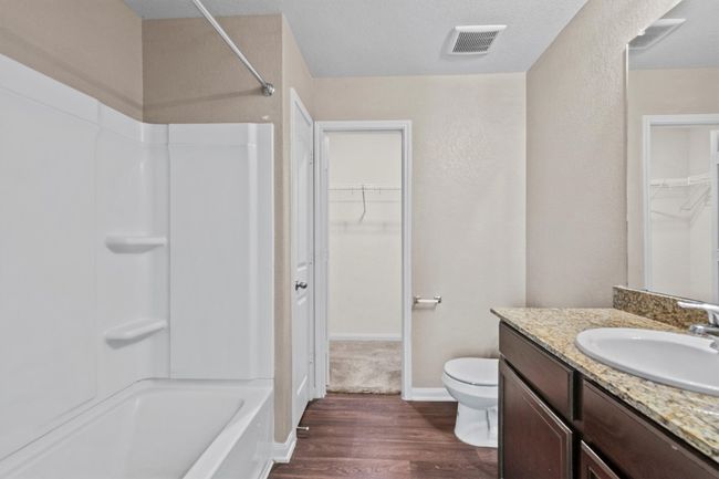 Full bath with visible vents, vanity, wood finished floors, toilet, and shower combination | Image 12