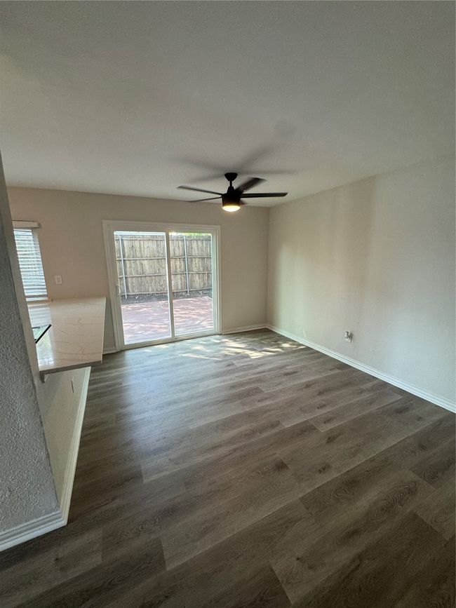Empty room with a ceiling fan, dark wood finished floors, and baseboards | Image 7