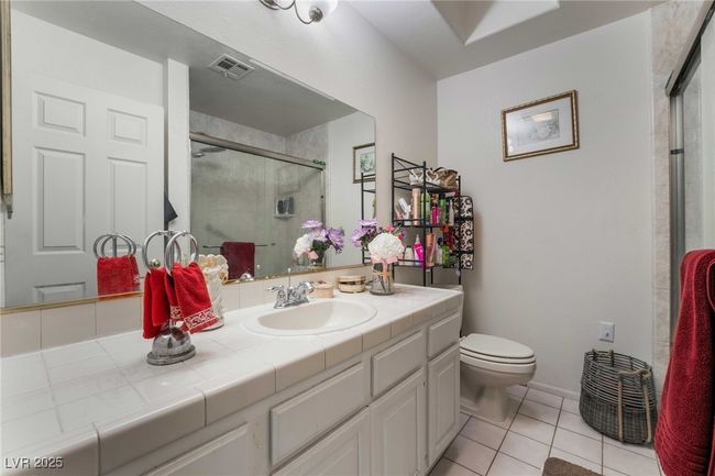Full bathroom featuring a shower stall, visible vents, toilet, vanity, and tile patterned flooring | Image 23