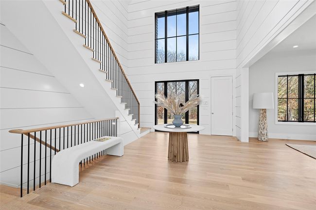 Foyer with wood finished floors, a high ceiling, stairway, recessed lighting, and baseboards | Image 10