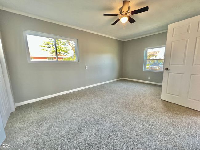 unfurnished bedroom featuring a ceiling fan, baseboards, ornamental molding, and carpet floors | Image 11