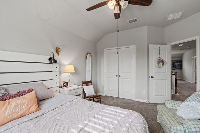 Carpeted bedroom with a closet, baseboards, vaulted ceiling, and a ceiling fan | Image 32