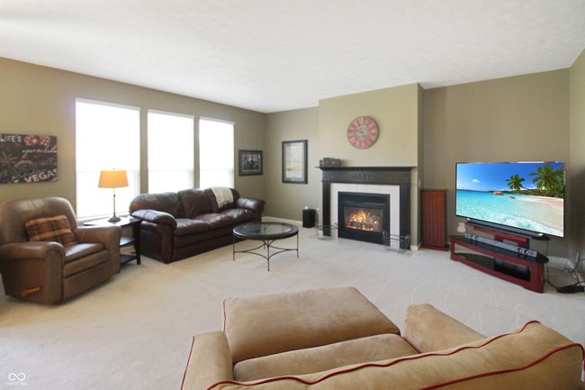 This inviting great room is the heart of the home, featuring a cozy gas fireplace, a seamless open flow, and windows that bring the beauty of the backyard indoors | Image 10