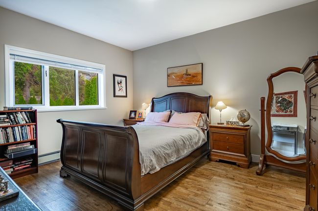 Bedroom featuring a baseboard heating unit and wood finished floors | Image 18