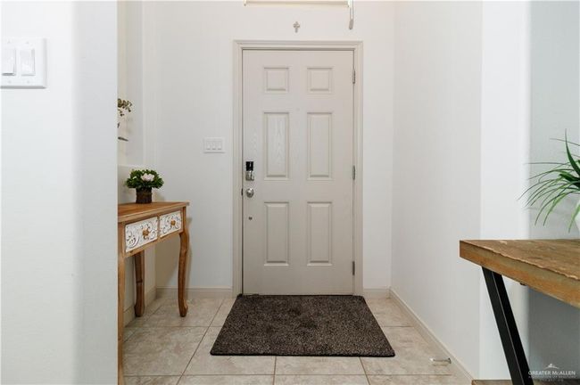 Entrance foyer featuring light tile patterned flooring and baseboards | Image 4