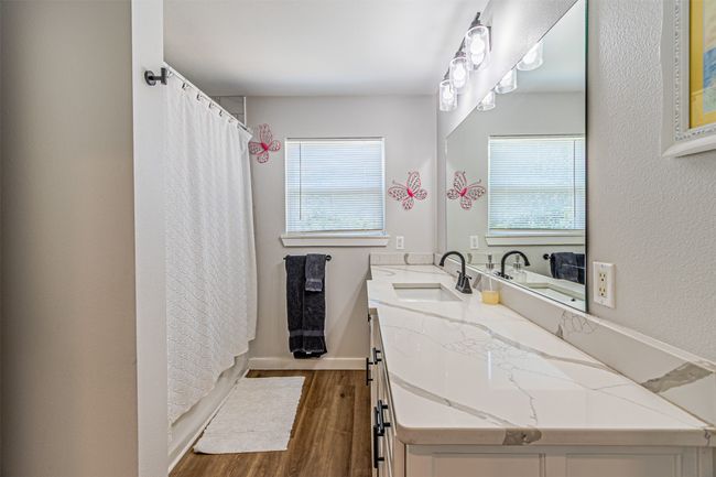 Full bathroom with wood finished floors, plenty of natural light, vanity, and a shower with shower curtain | Image 26