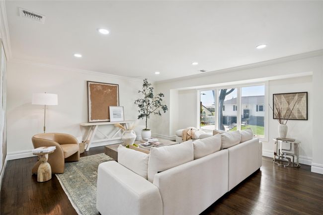 Living area with crown molding, recessed lighting, and dark wood-style floors | Image 11