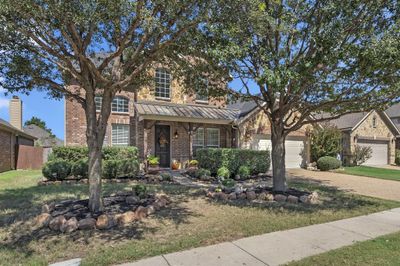 View of front of house featuring a front lawn and a garage | Image 1