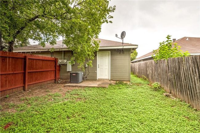 Rear view of house with a fenced backyard and a shingled roof | Image 8