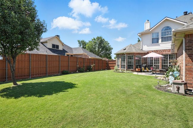 Fenced backyard with a patio area | Image 32