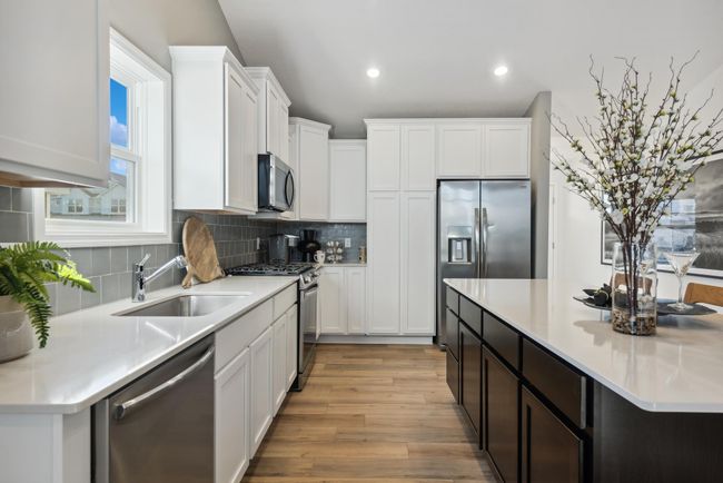 *Photo of model home, actual features may vary. This thoughtfully-designed kitchen layout features stainless steel appliances and quartz countertops. | Image 5