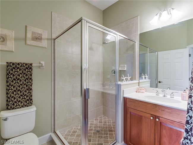Bathroom featuring a shower with door, vanity, and toilet | Image 26