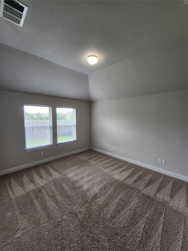 Carpeted empty room featuring lofted ceiling and baseboards | Image 11