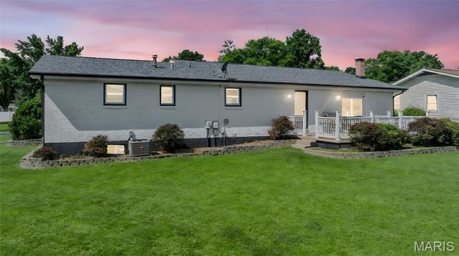 Rear view of property with a chimney, a yard, a deck, and roof with shingles | Image 28