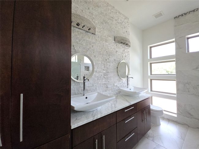 Bathroom with double vanity, marble finish flooring, and toilet | Image 16