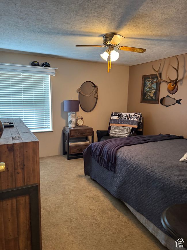 Bedroom with light carpet, a textured ceiling, and ceiling fan | Image 12