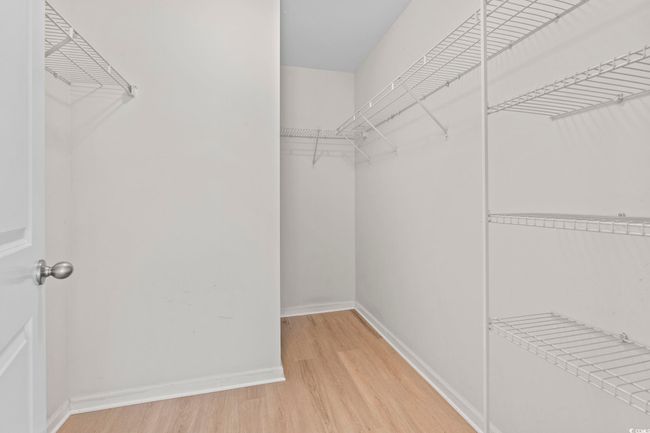 Spacious closet featuring light wood-type flooring | Image 18