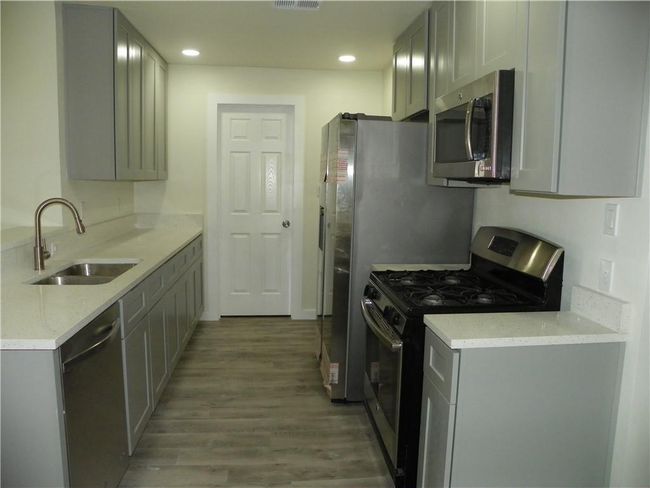 Kitchen featuring appliances with stainless steel finishes, wood finished floors, gray cabinets, and recessed lighting | Image 5