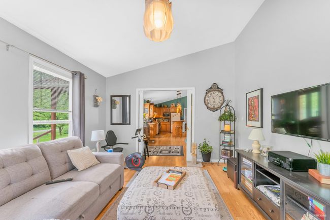 Living room featuring light wood-style flooring and lofted ceiling | Image 6